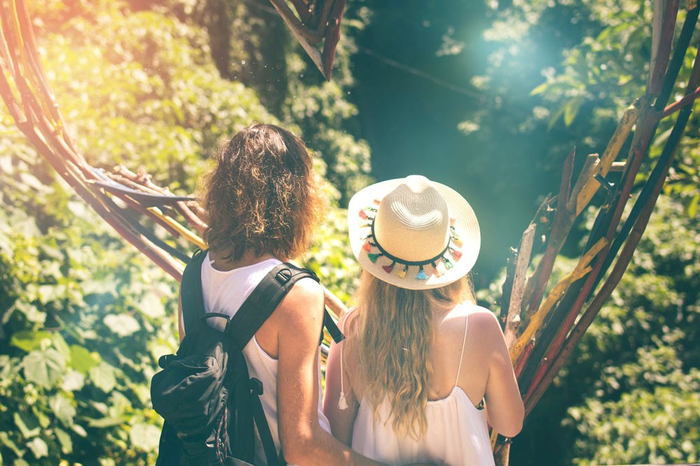 Pareja de espaldas a la cámara y mirando a la naturaleza